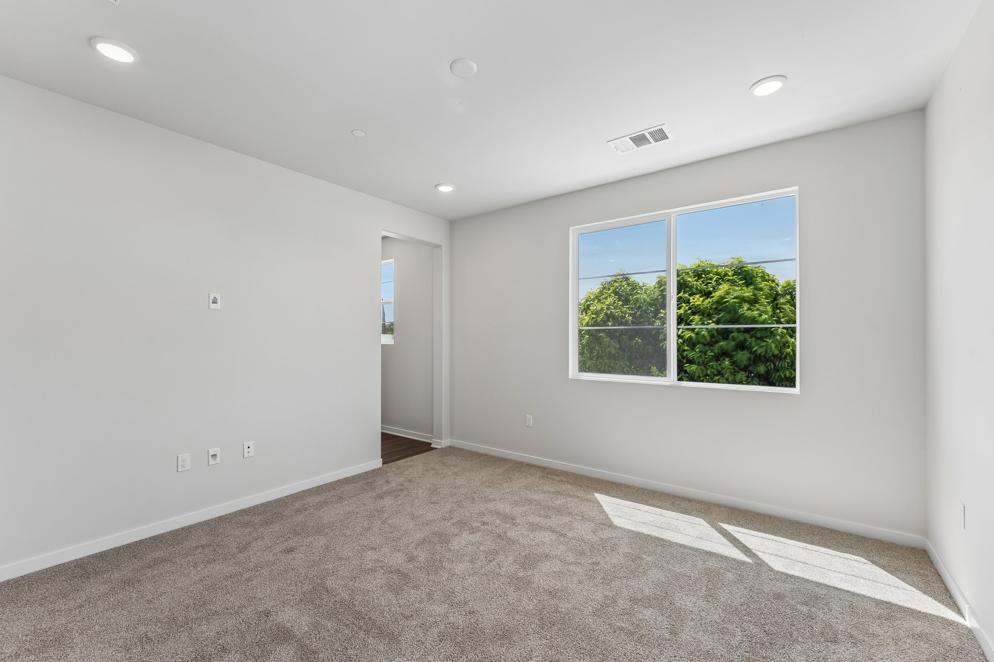 A room with a window and a carpet.