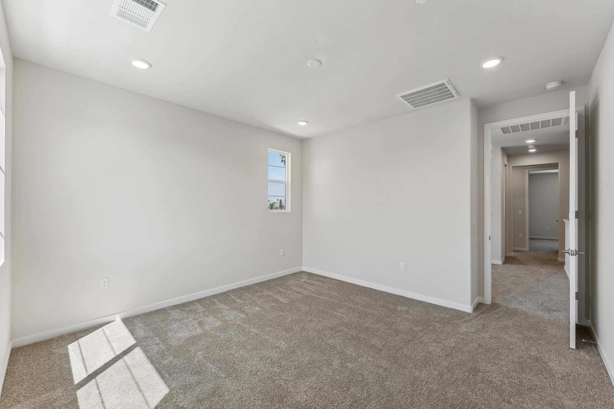 A room with a carpet and a window.