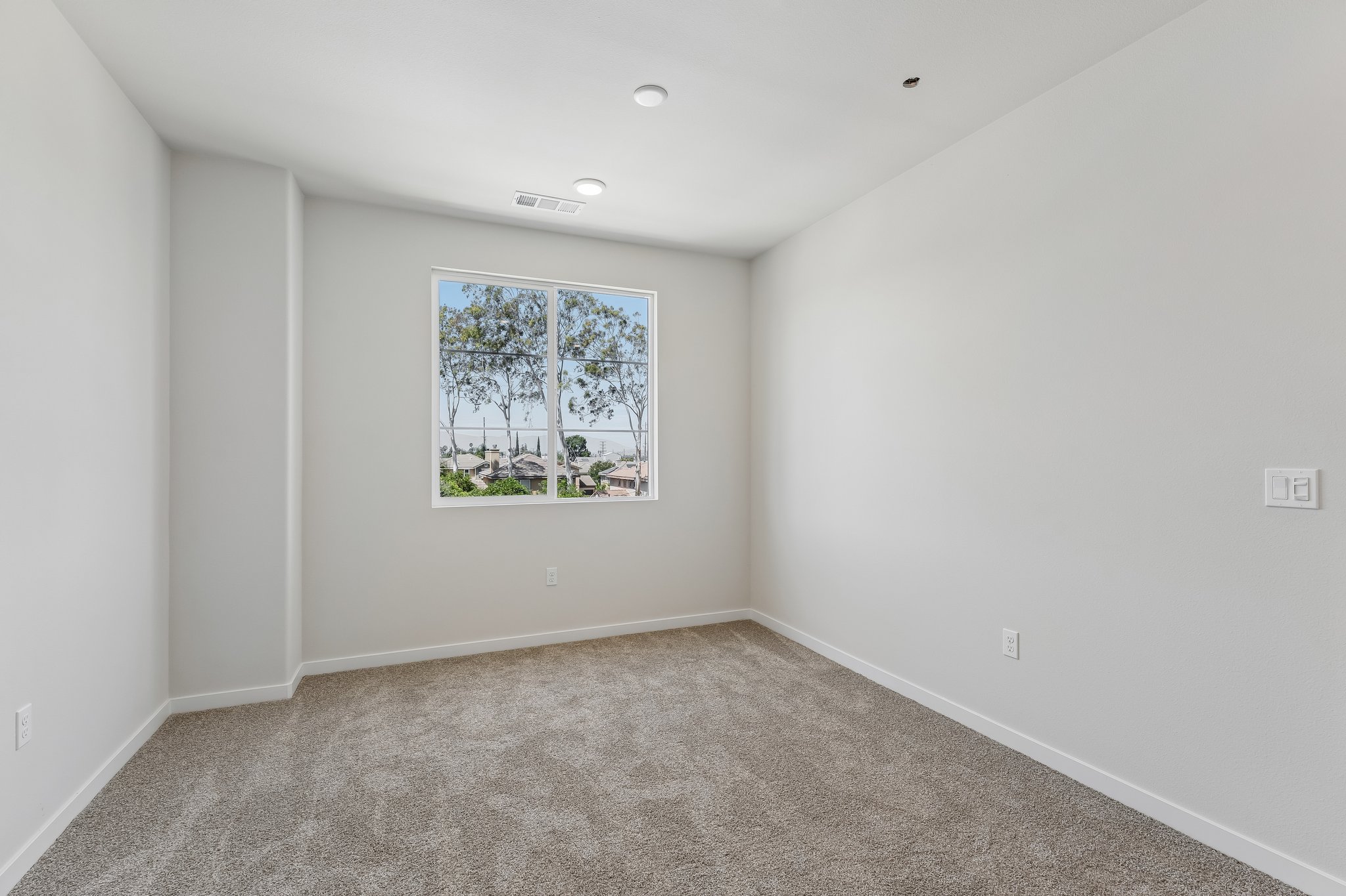 A room with a window and carpet.