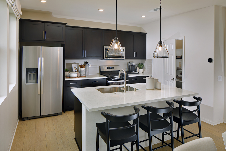 A kitchen with a bar and a dining table.