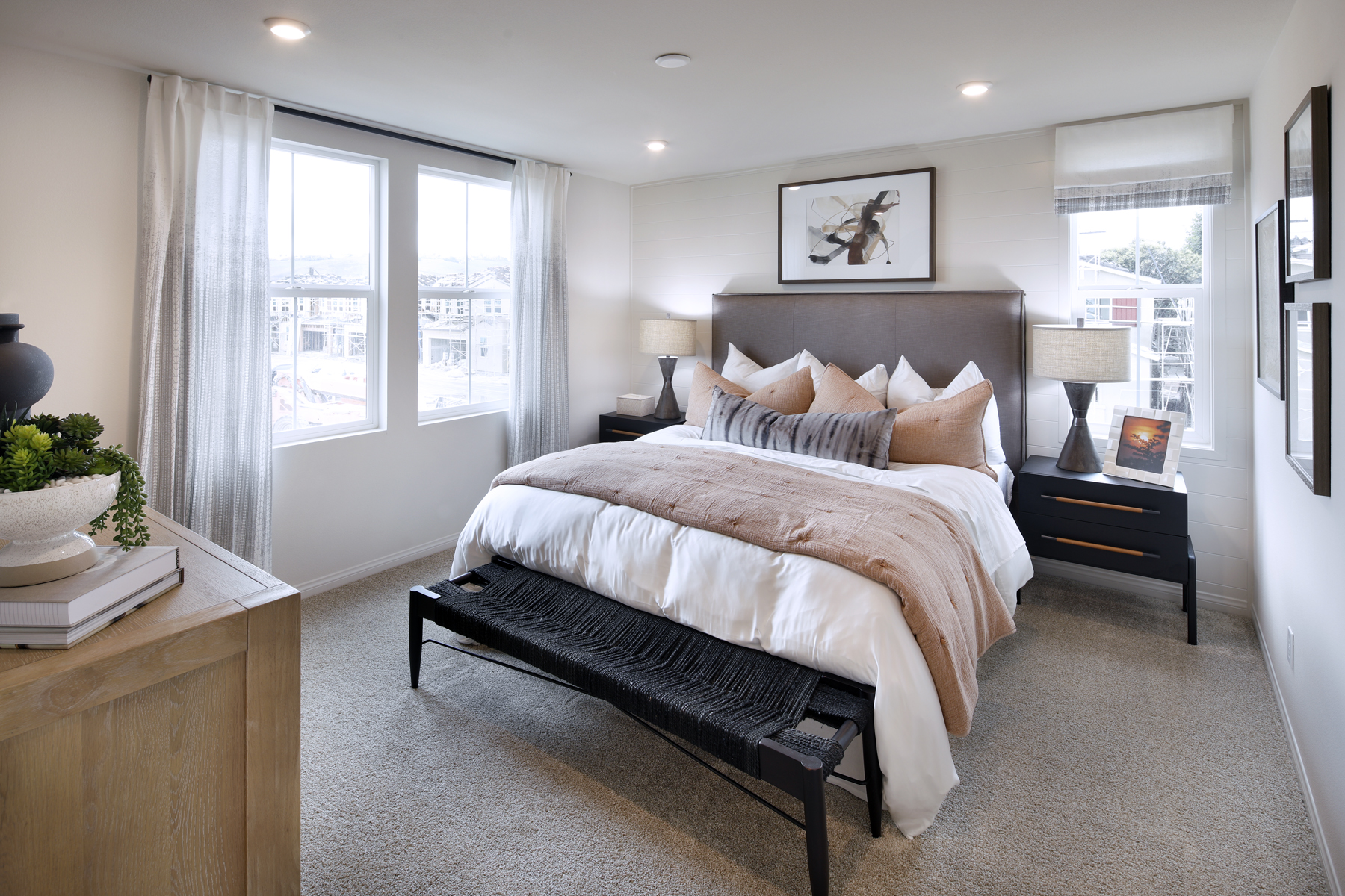 A bedroom with a bed and a bench.