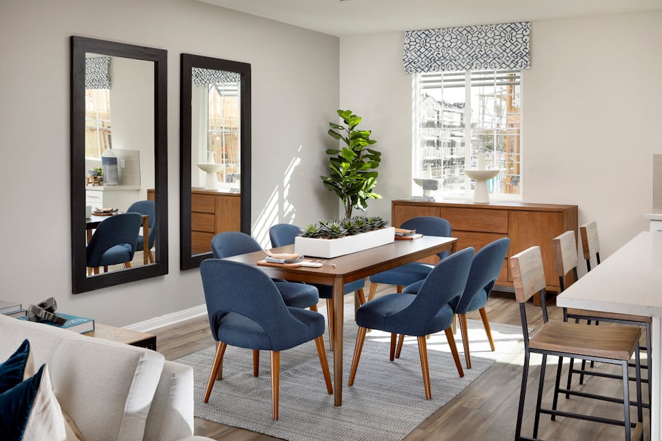 A room with a table chairs and a plant.