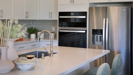 A kitchen with white cabinets.