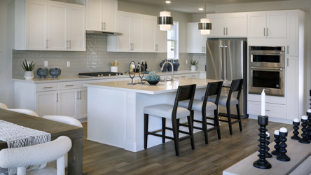 A kitchen with white cabinets.