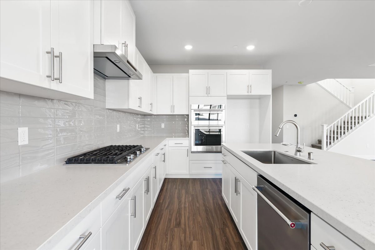 A kitchen with white cabinets.