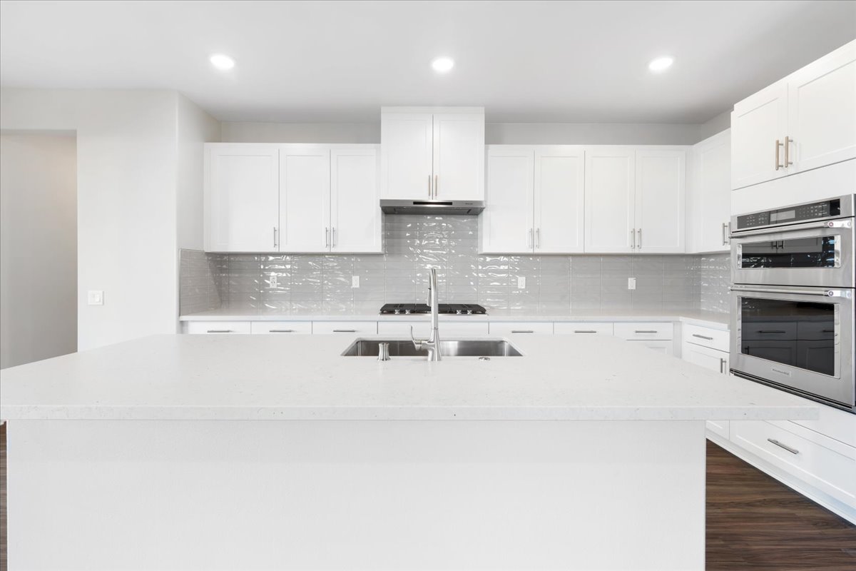 A kitchen with white cabinets.