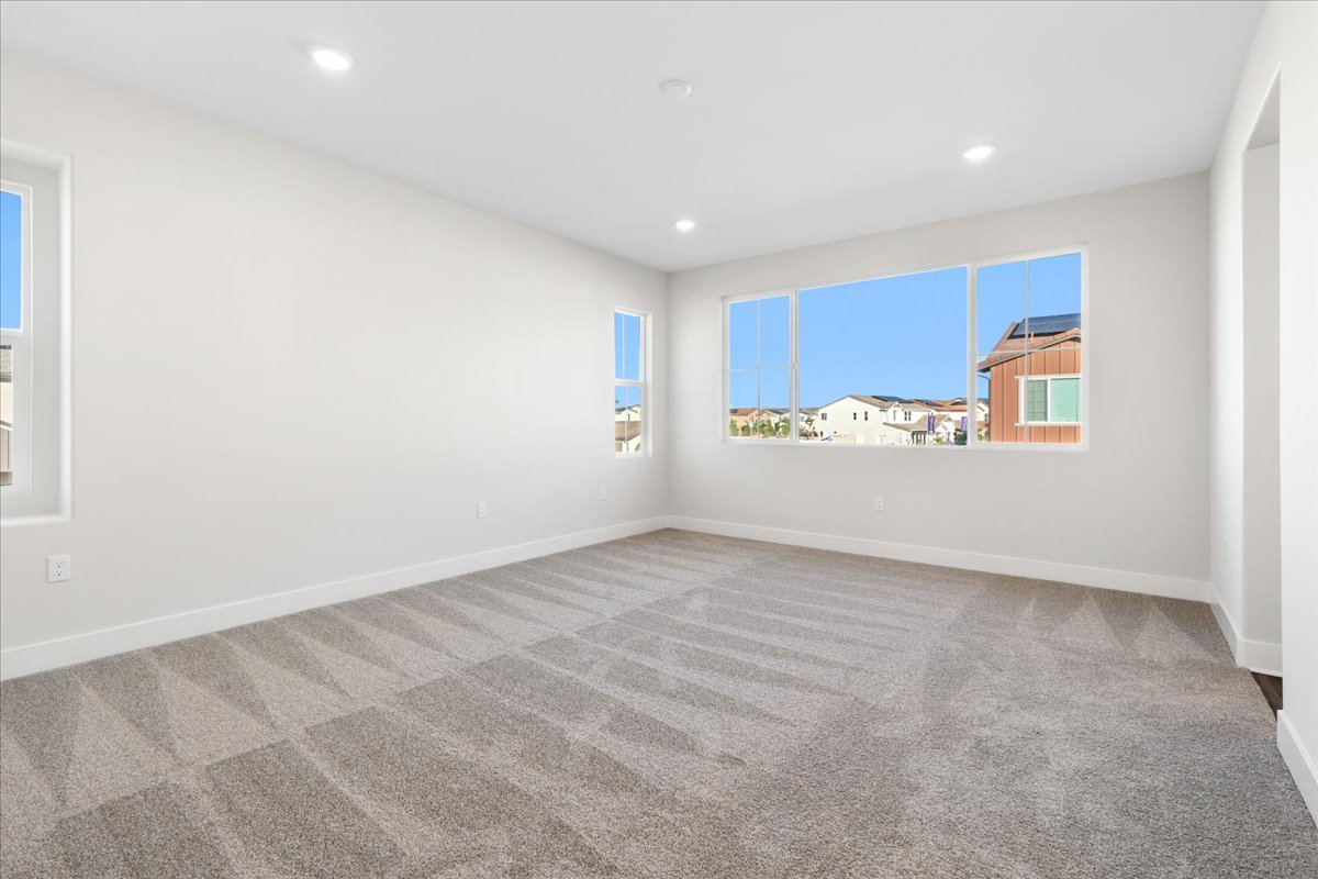 A room with a carpet and windows.