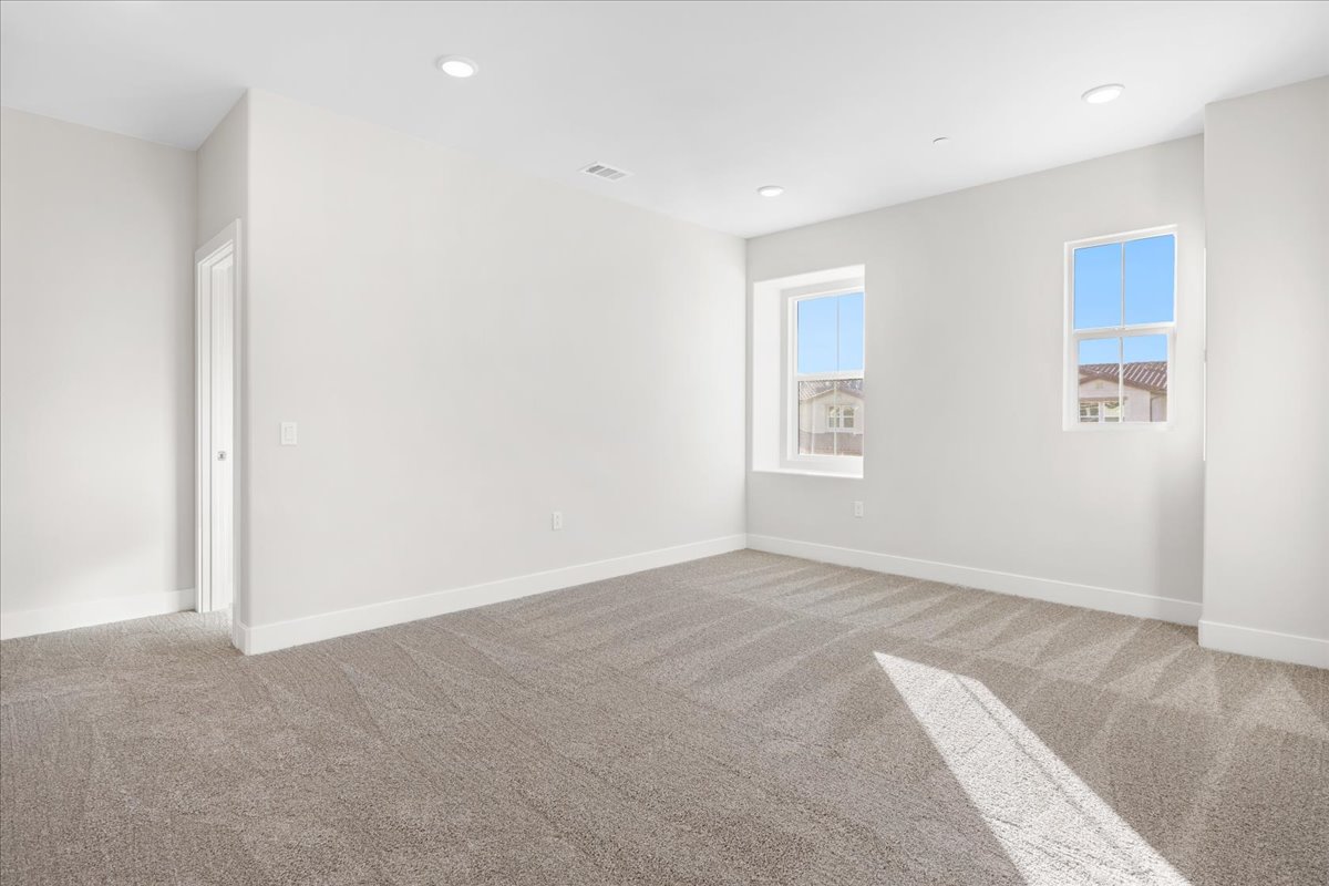 A room with a carpet and windows.