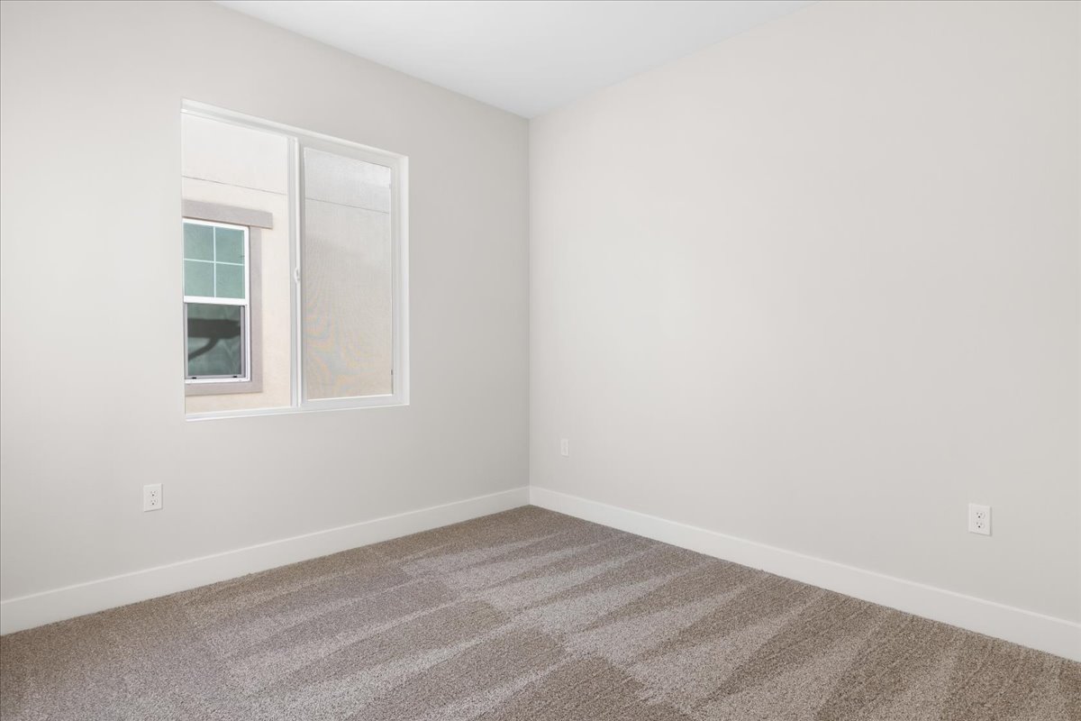 A room with a window and a rug.