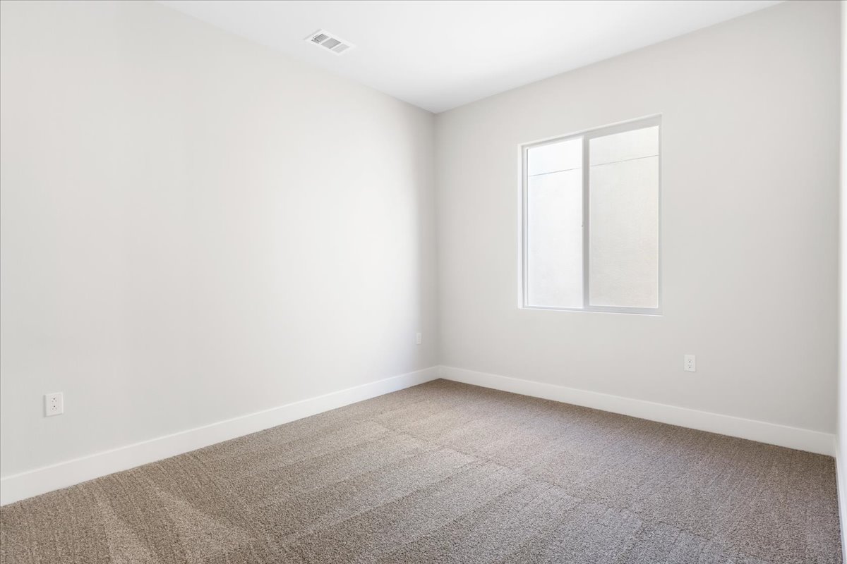 A room with a carpet and a window.