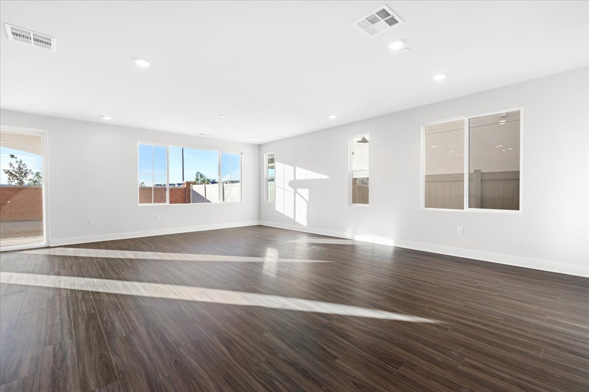A large empty room with a wood floor and a large window.