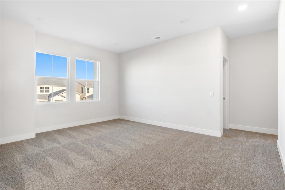 A room with a carpet and windows.