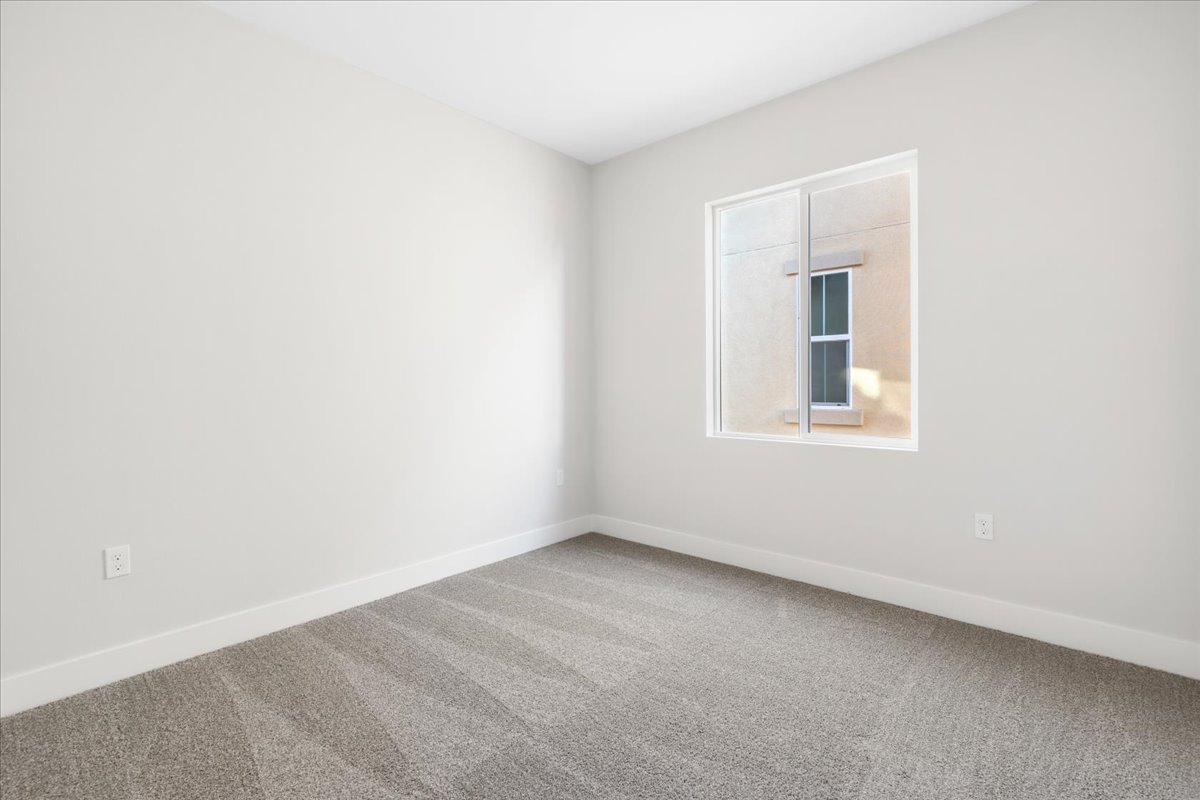 A room with a window and carpet.