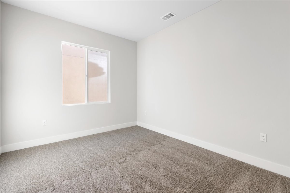 A room with a carpet and a window.