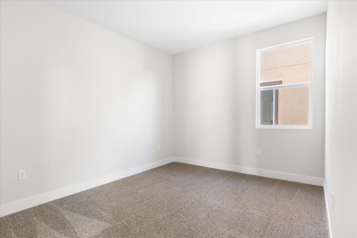 A room with a window and carpet.