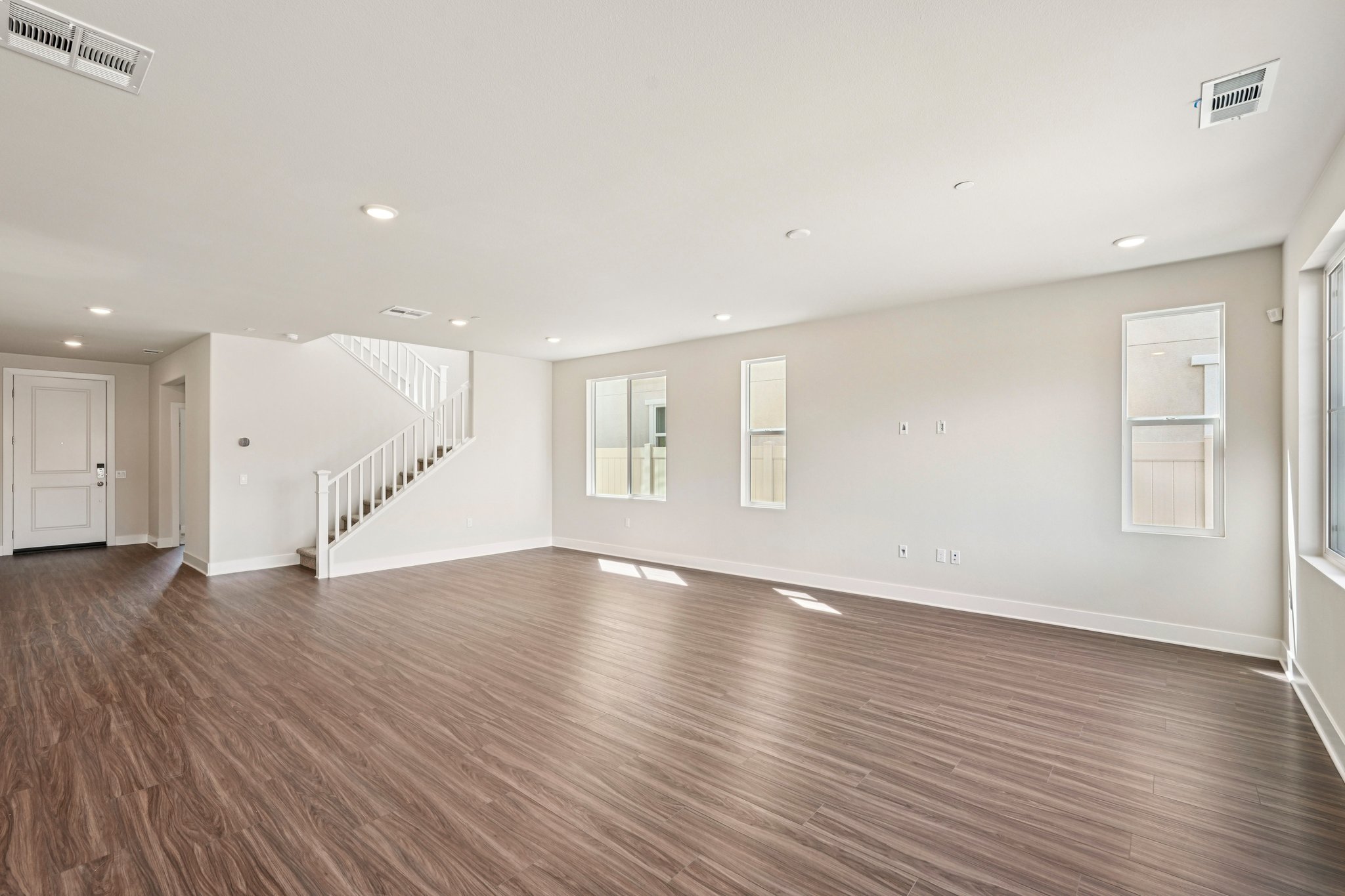 A large empty room with a wood floor and white walls.