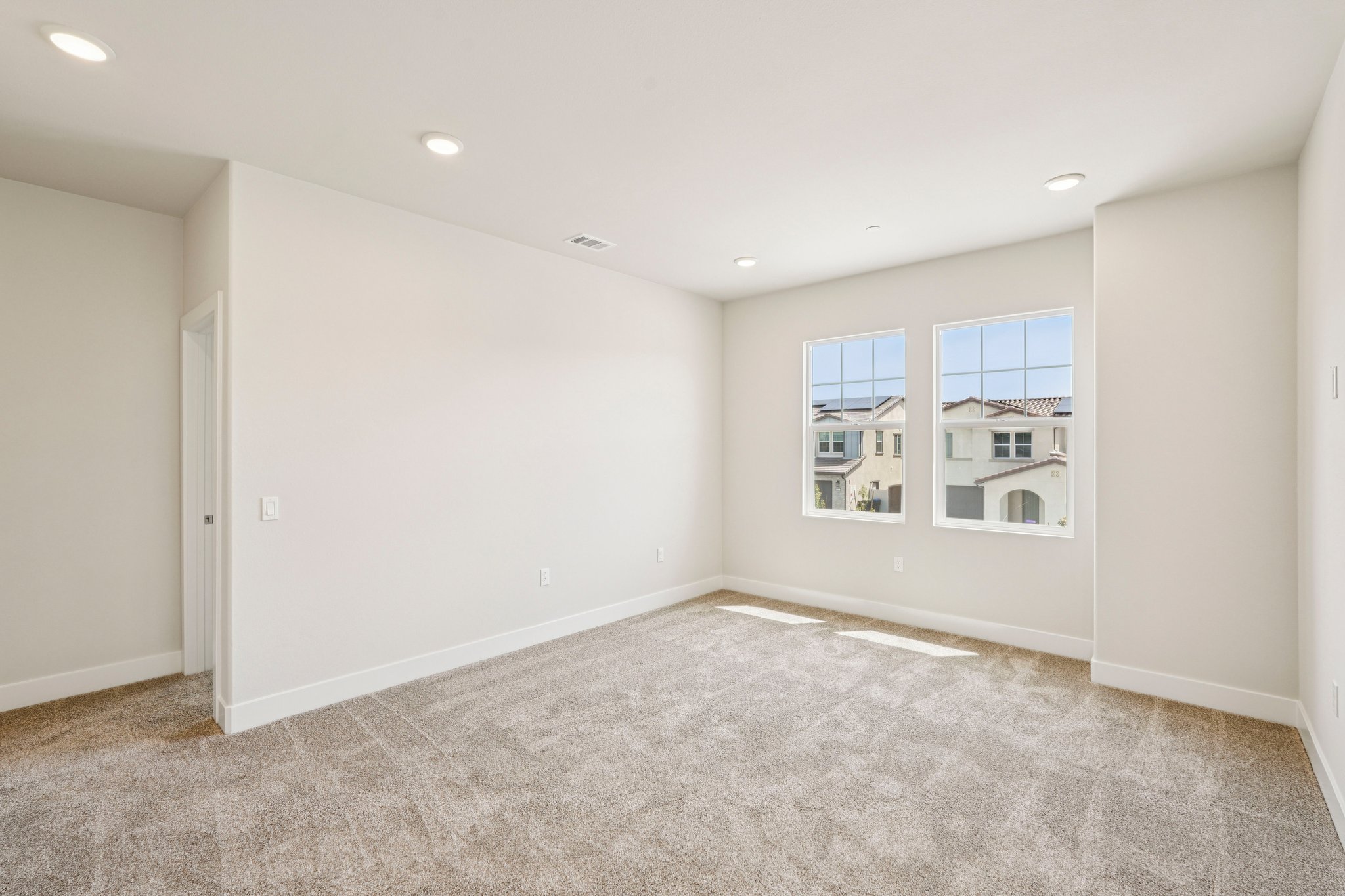 A room with a carpet and windows.