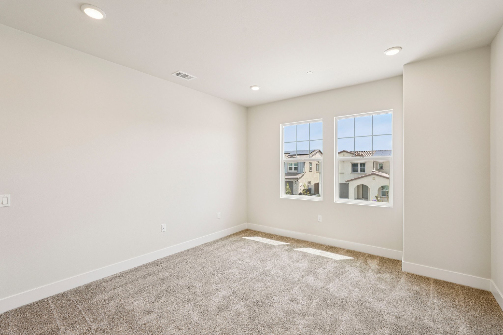A room with a carpet and windows.