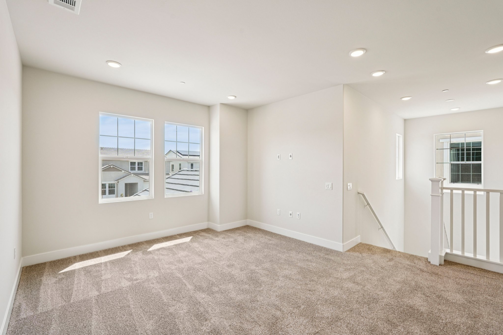 A room with a carpet and windows.