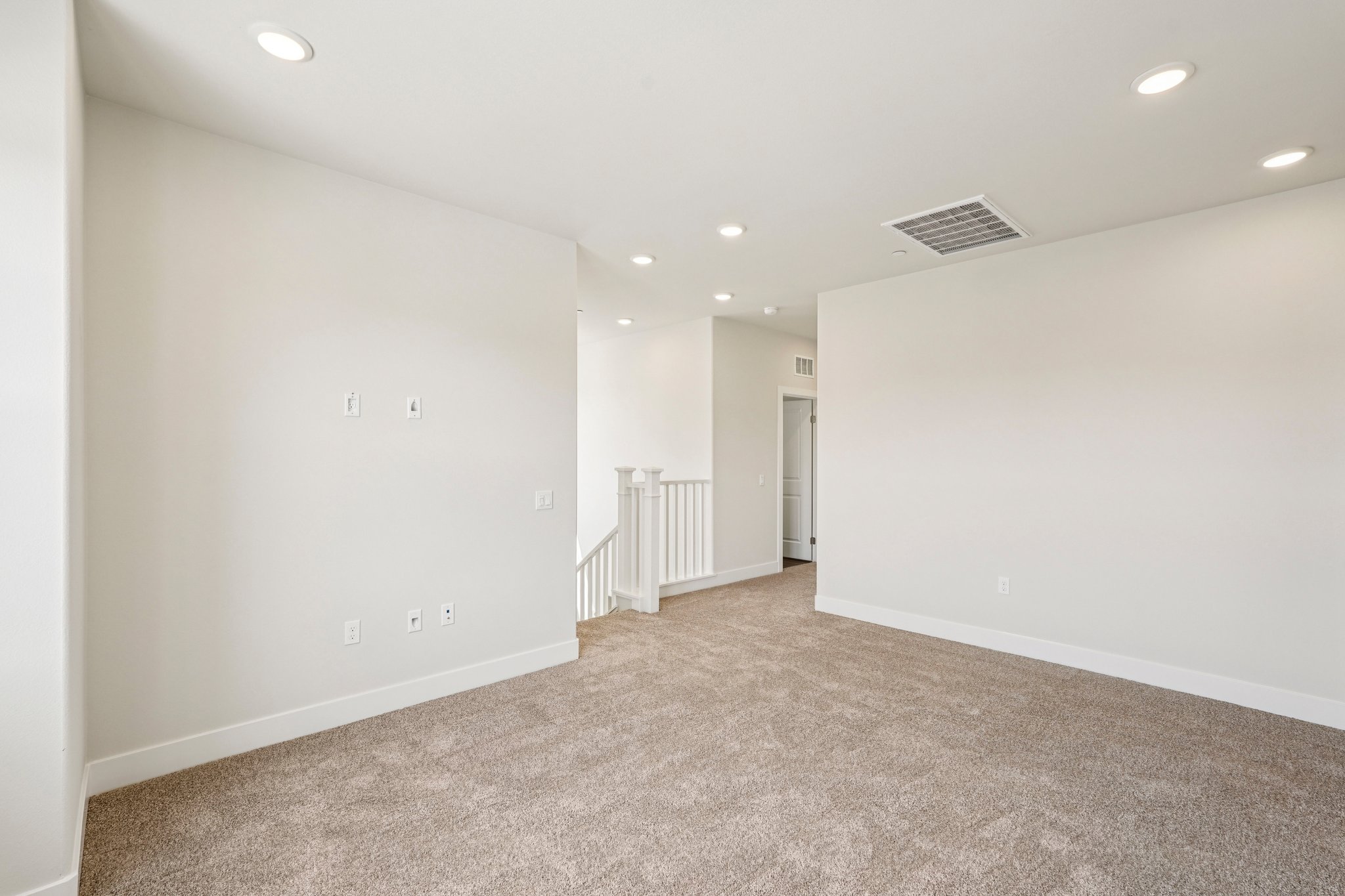 A room with a carpet and a white wall.