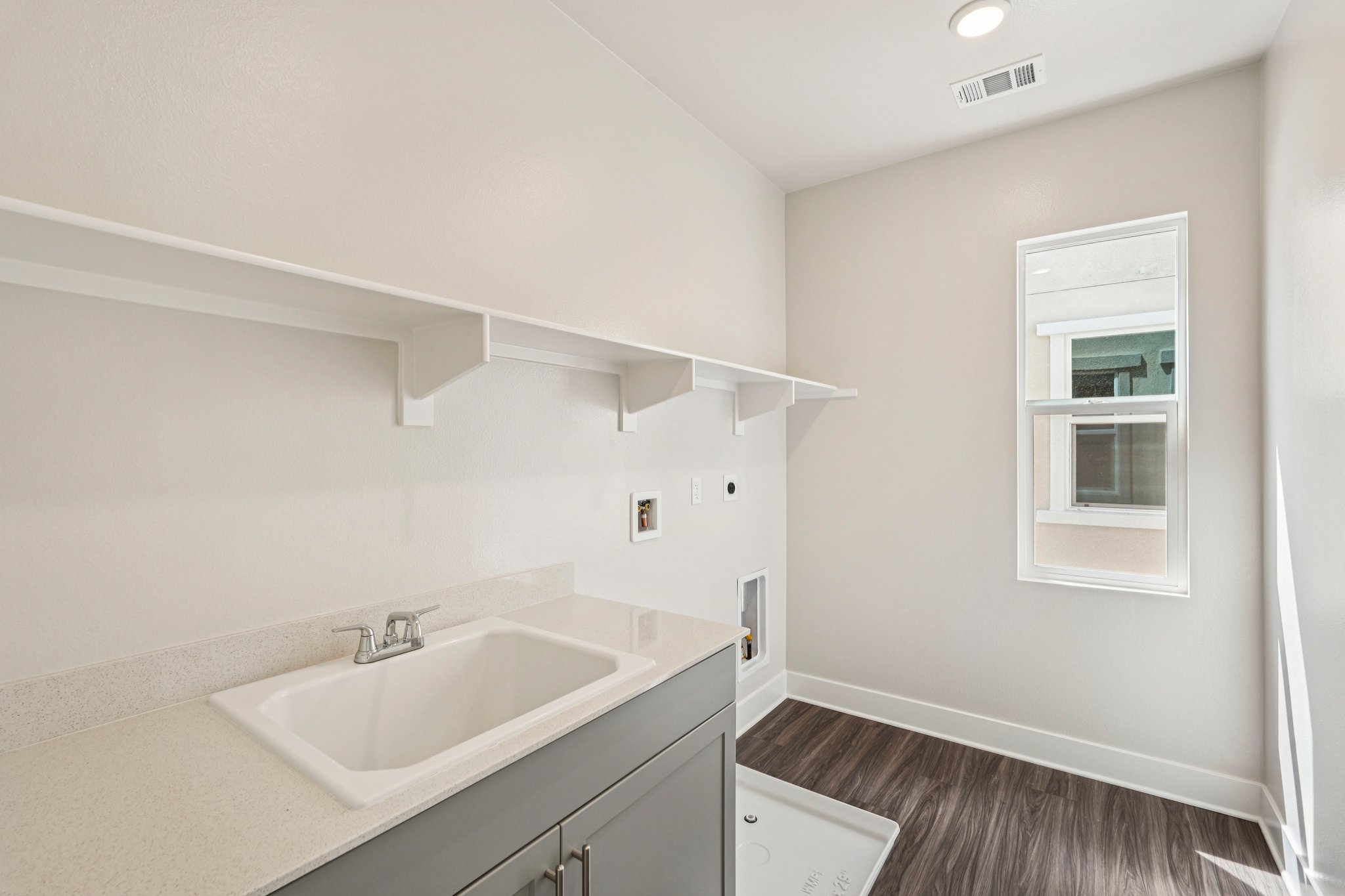 A bathroom with a sink and a window.