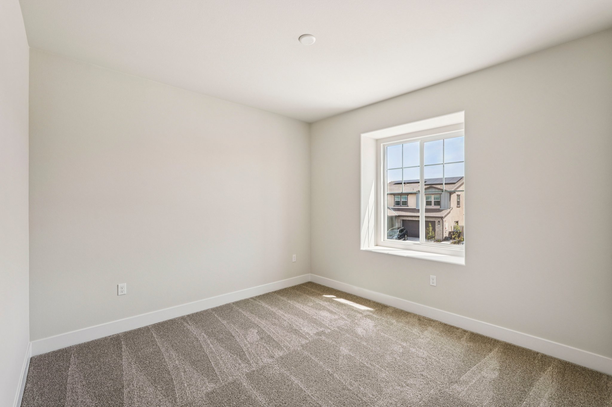 A room with a window and carpet.
