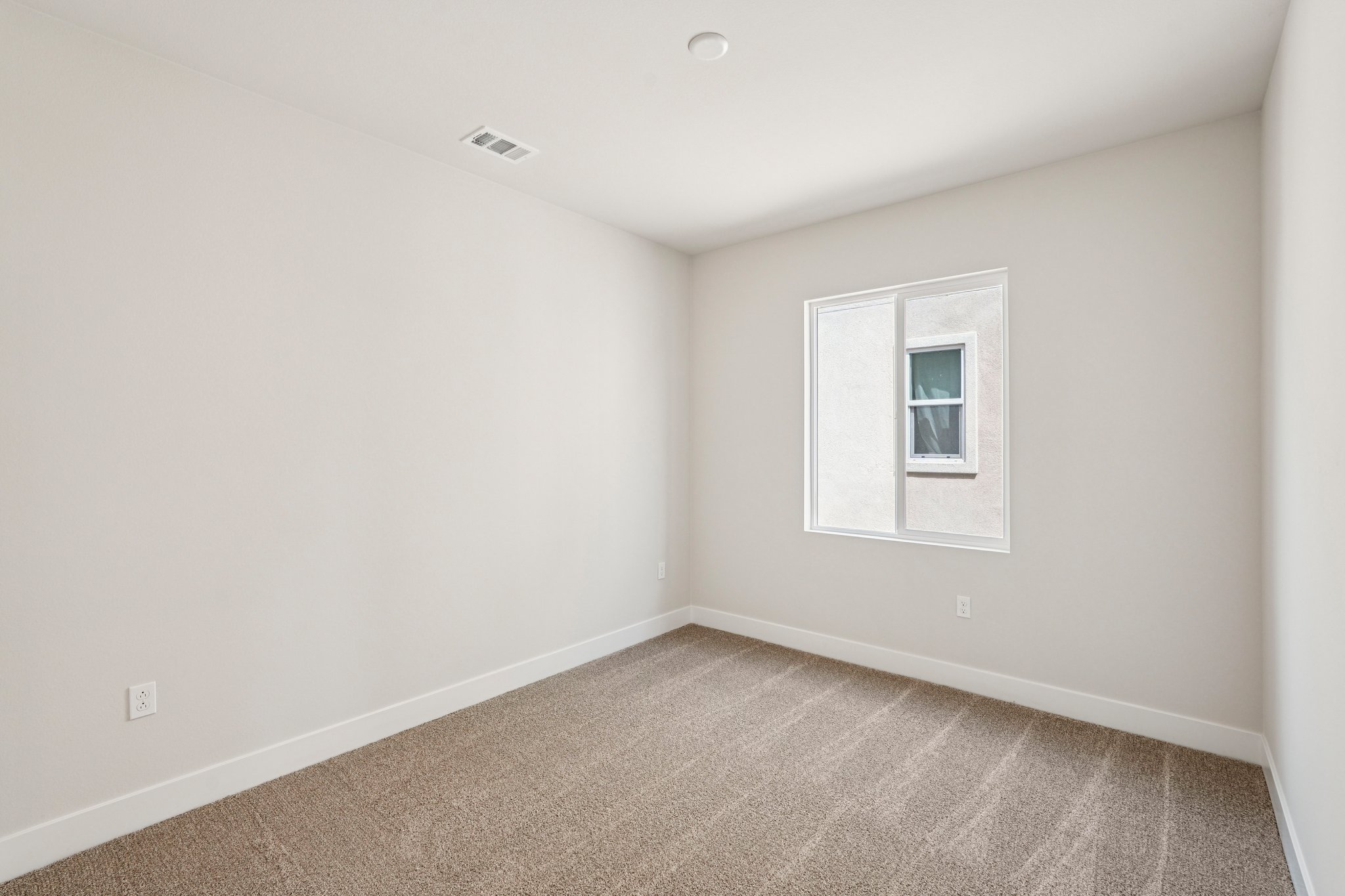 A room with a window and carpet.