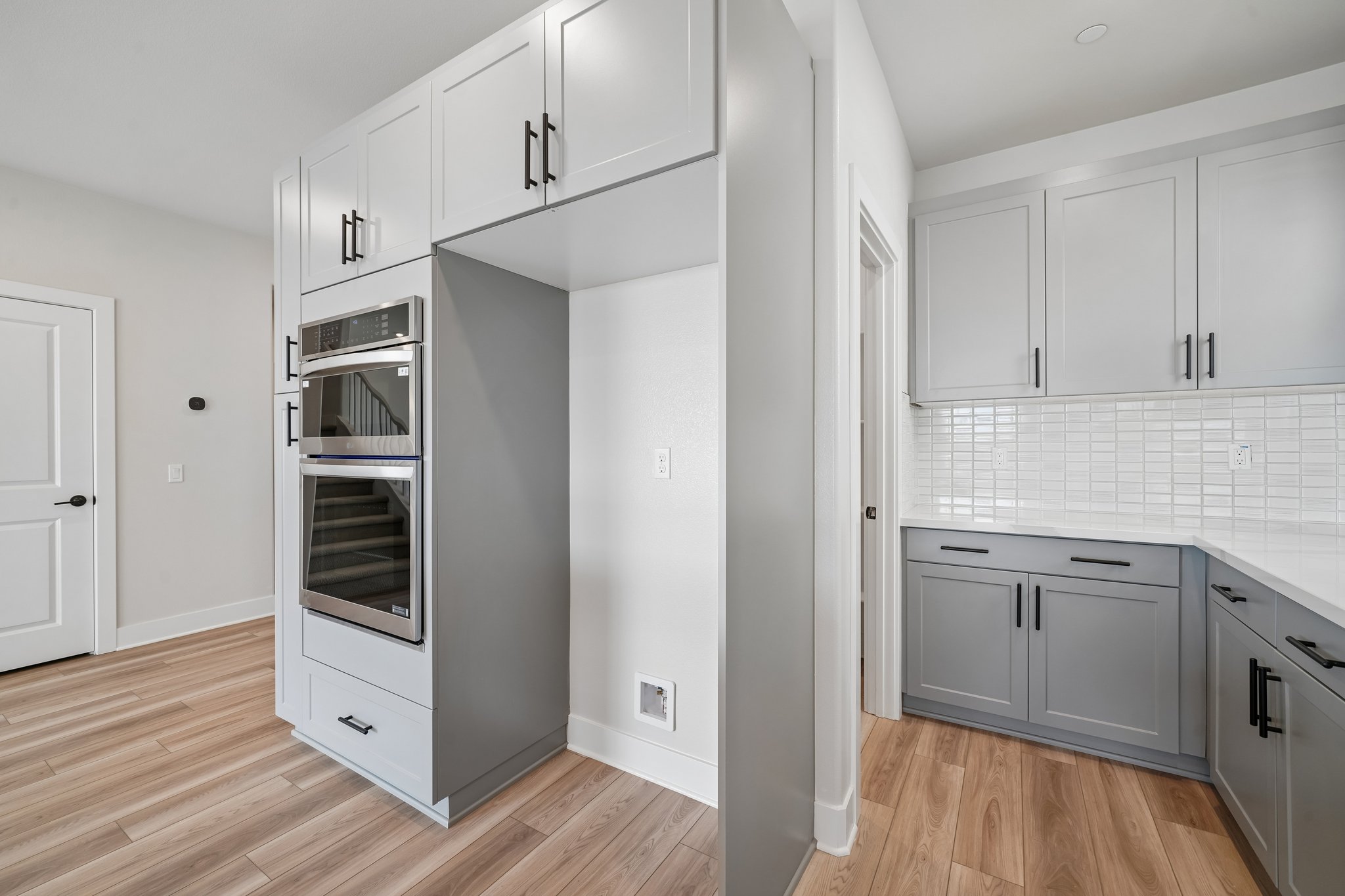 A kitchen with white cabinets.
