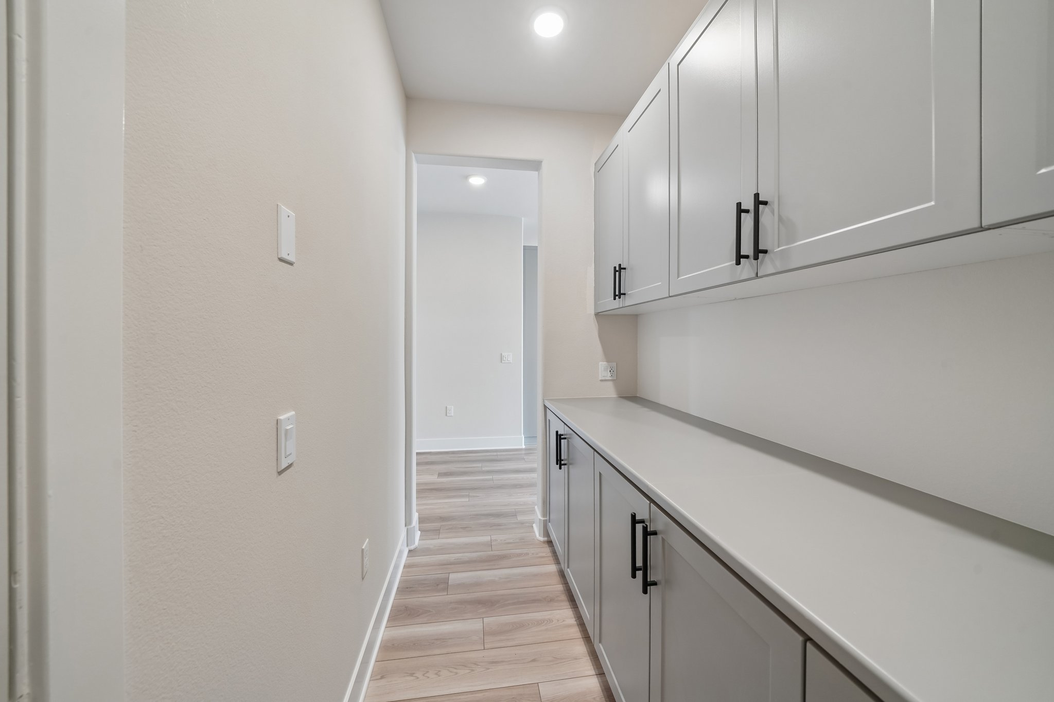 A kitchen with white cabinets.