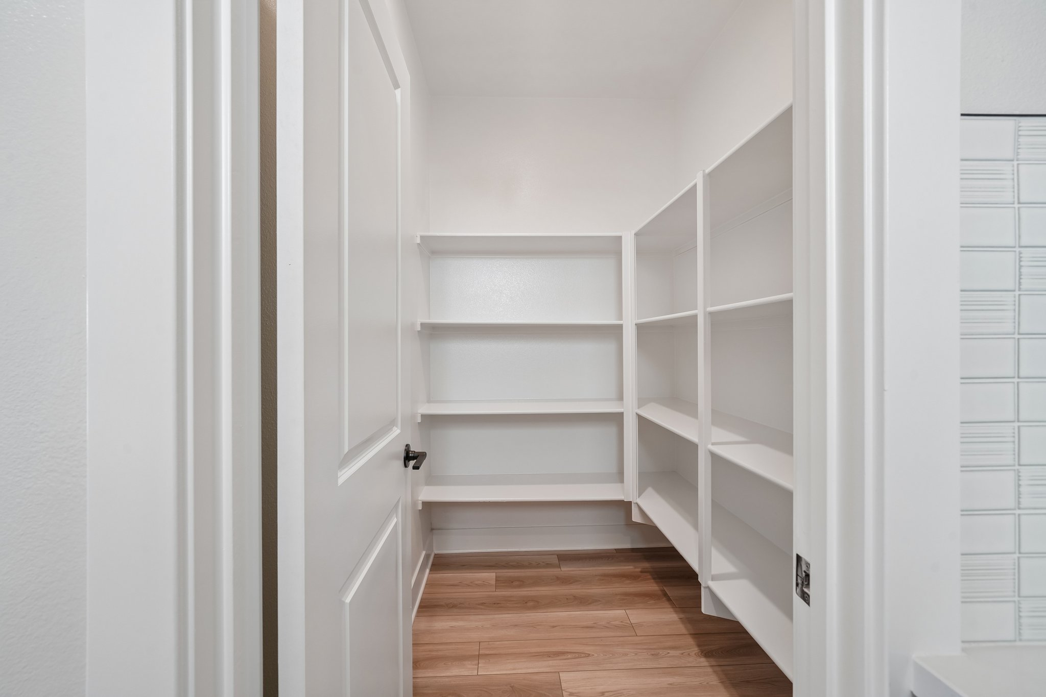 A white closet with white doors.