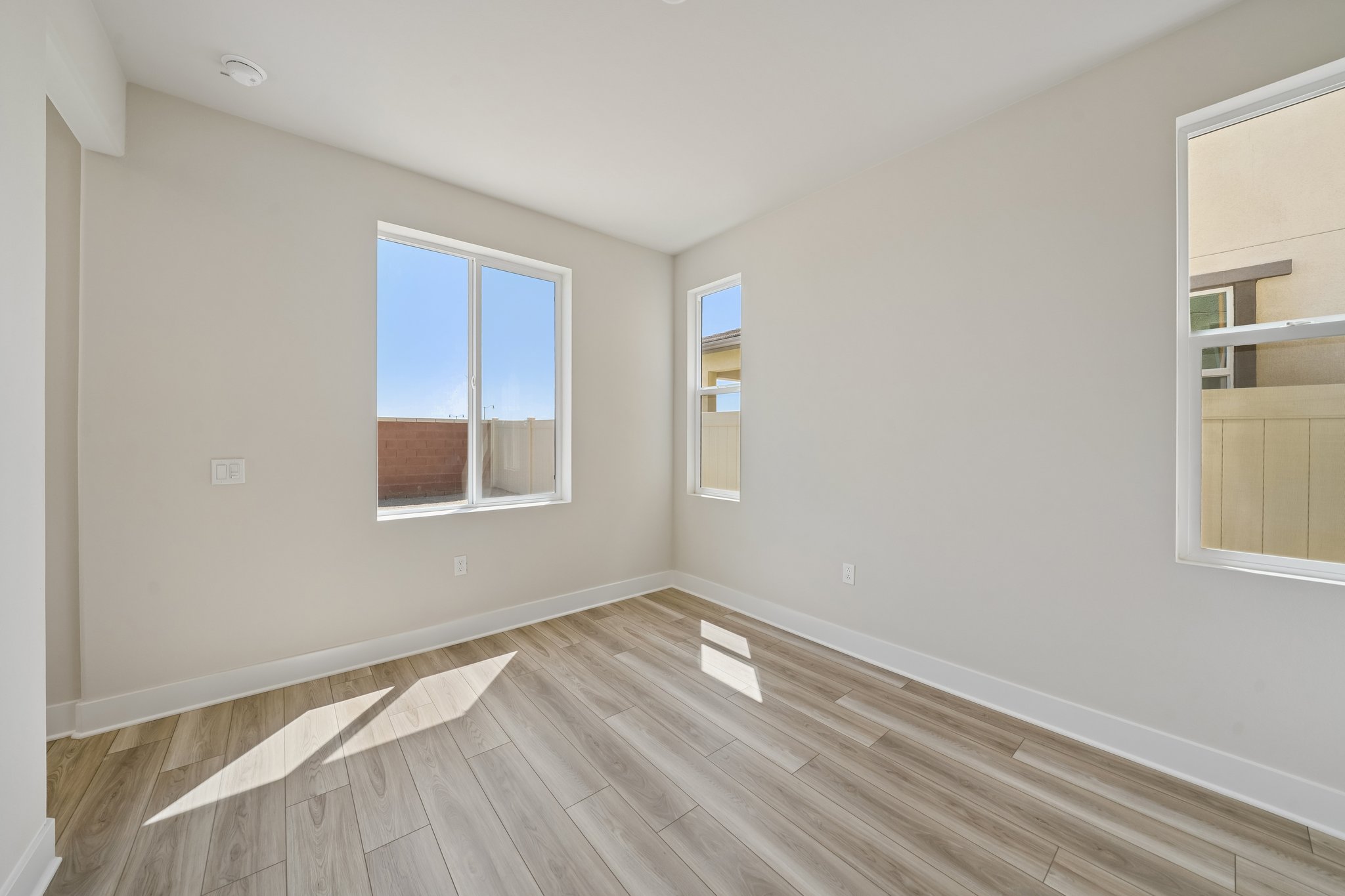 A room with a wood floor and windows.