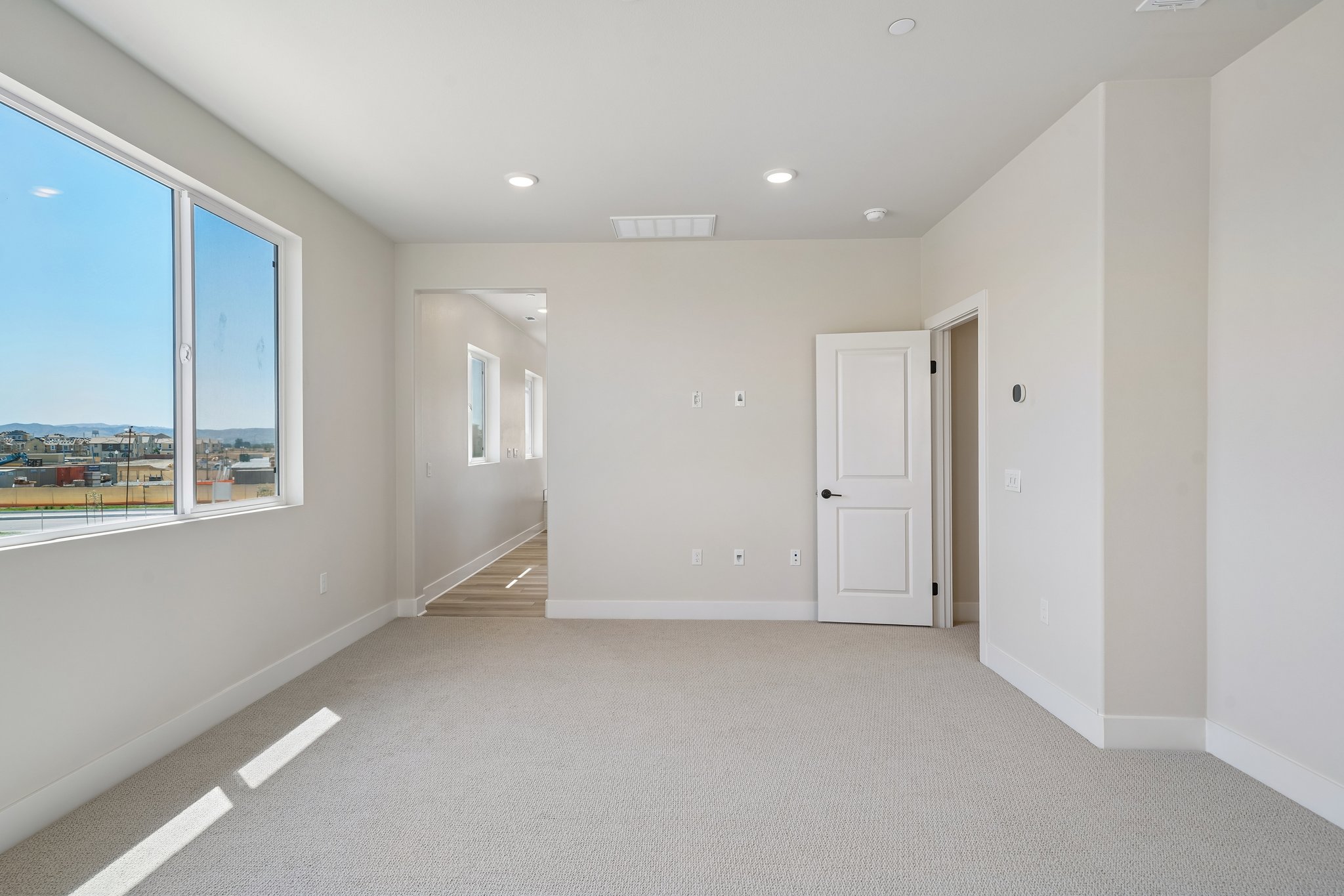 A room with white walls and a window.