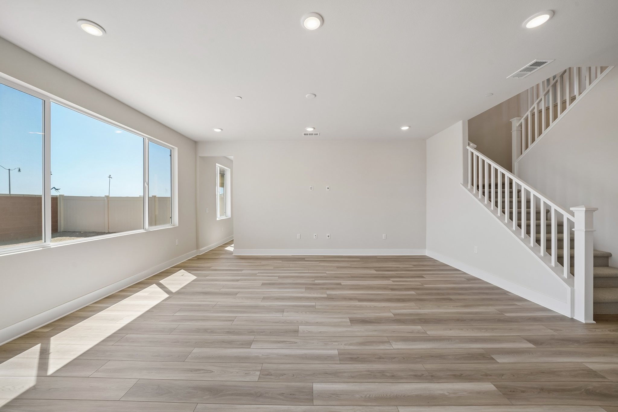 A large empty room with a wood floor and white walls.