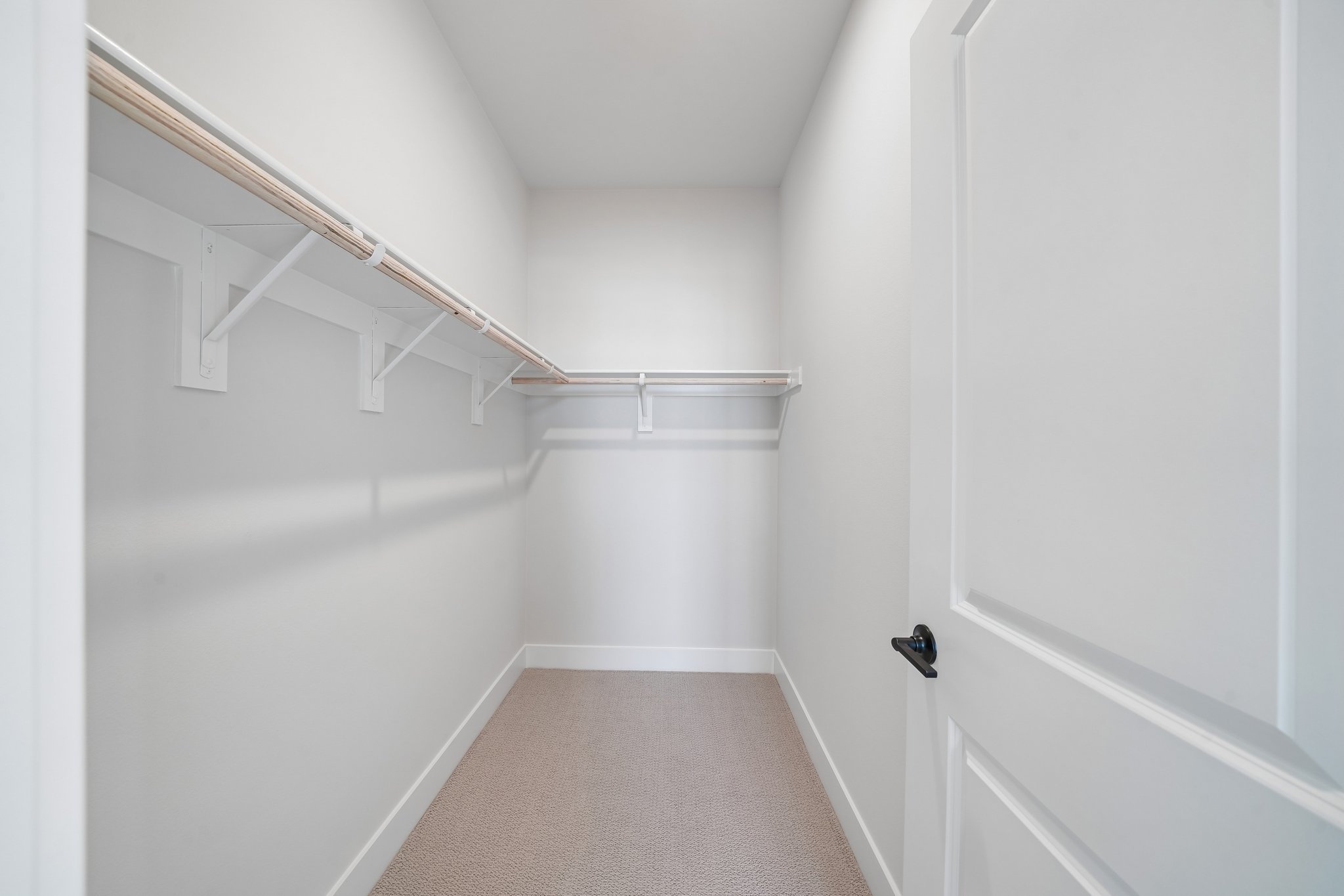 A white hallway with a white door.