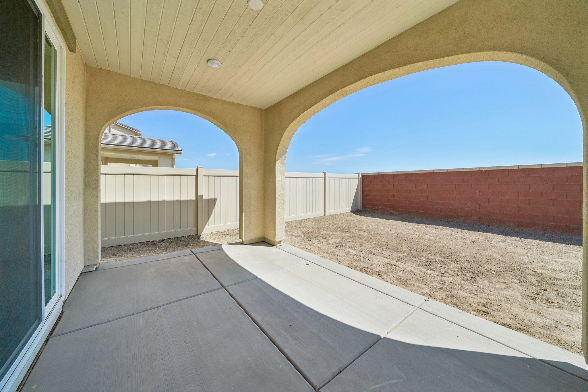 A walkway with a fence and a building in the background.