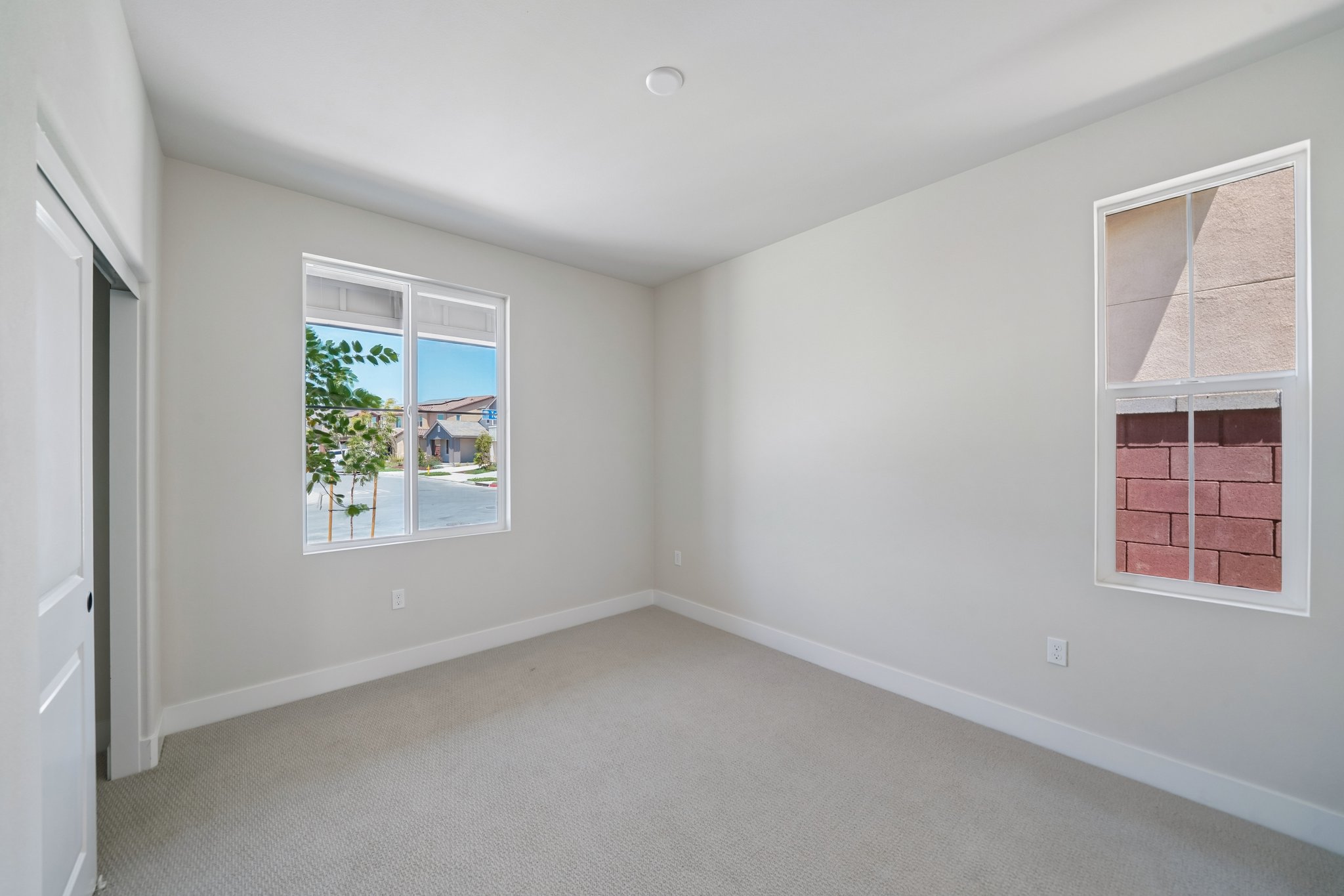 A room with windows and a white wall.