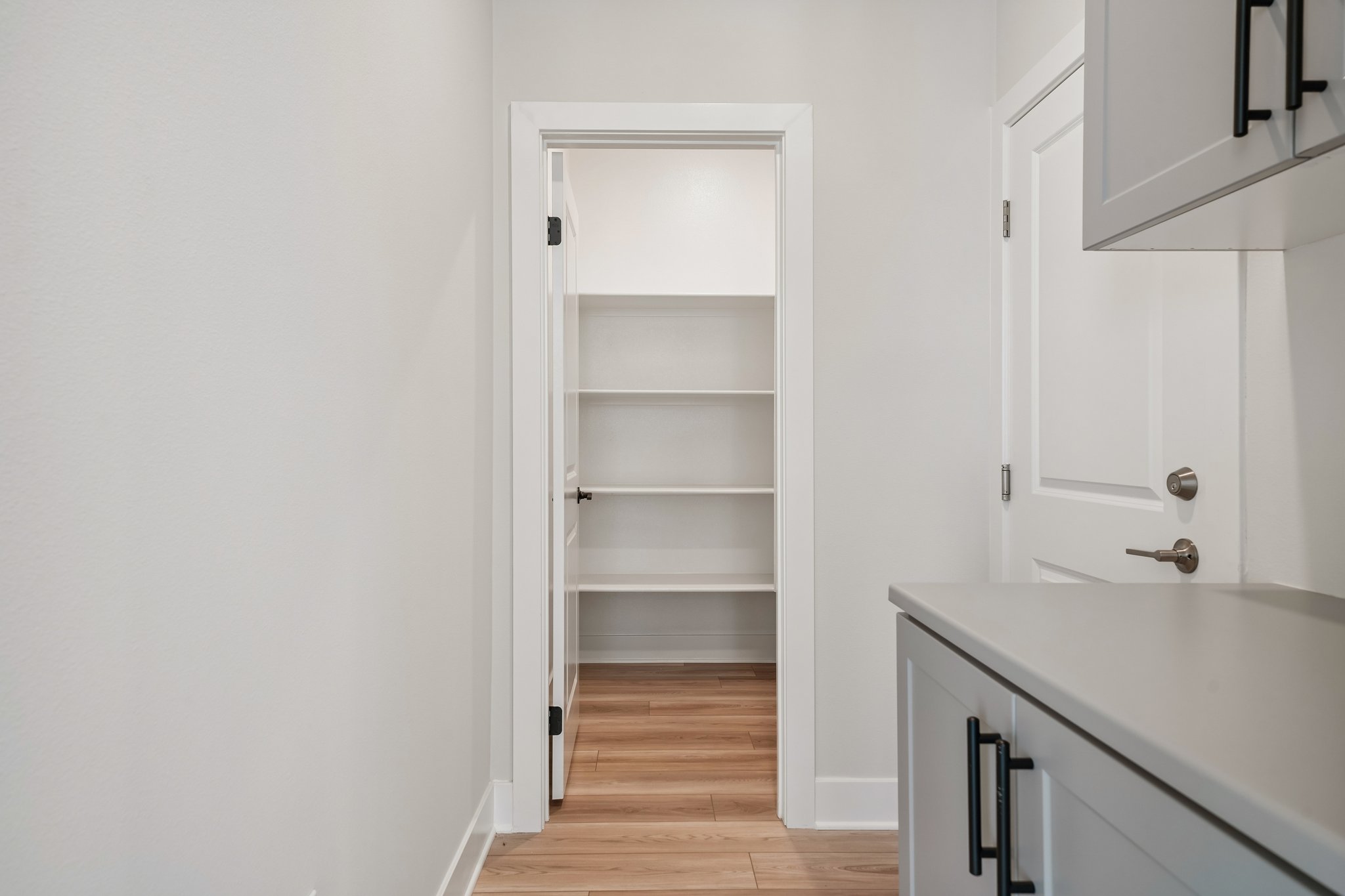 A white room with a white counter and a white cabinet.