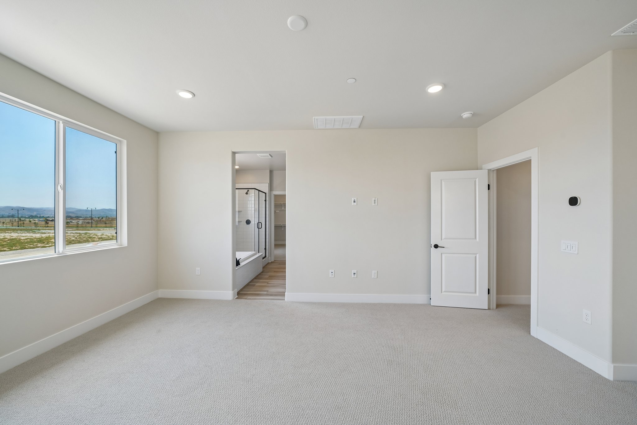 A room with white walls and a large window.