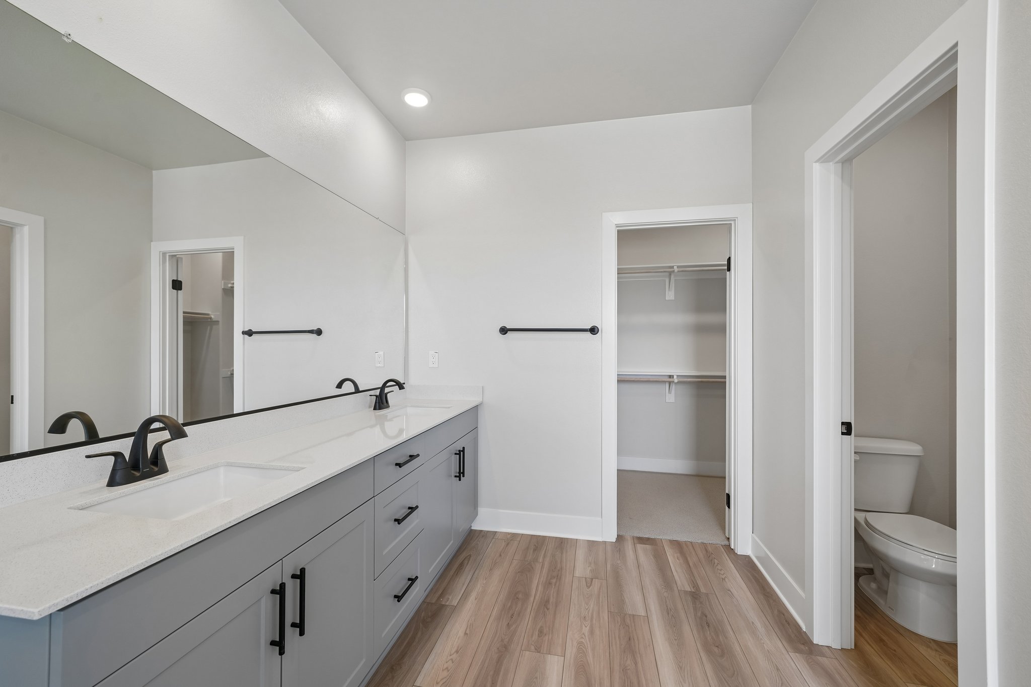 A bathroom with a sink toilet and mirror.