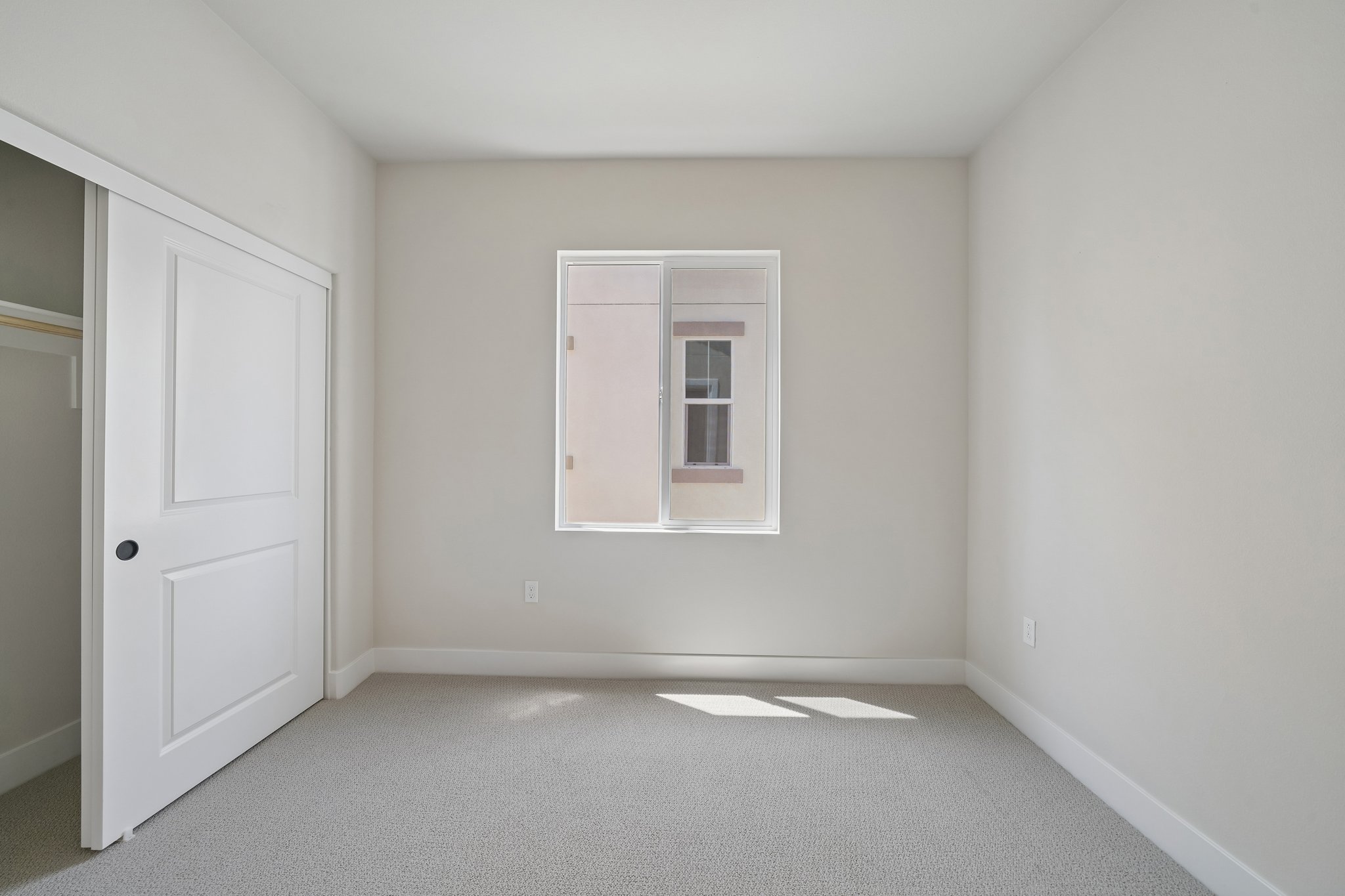 A room with a white door and a window.