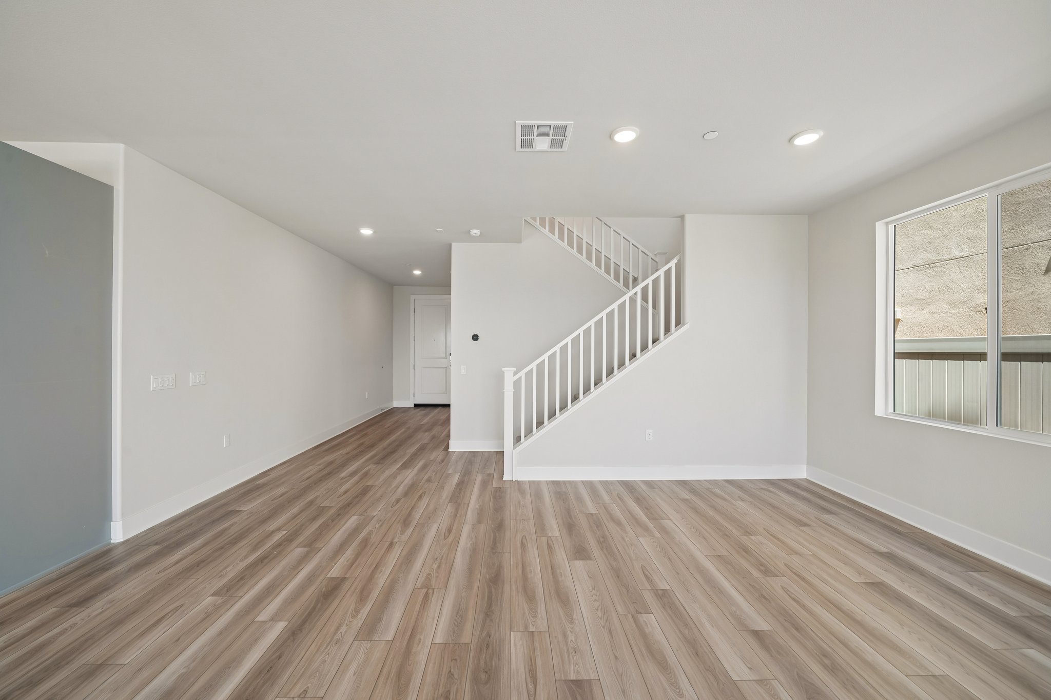 A room with a wood floor and white walls.