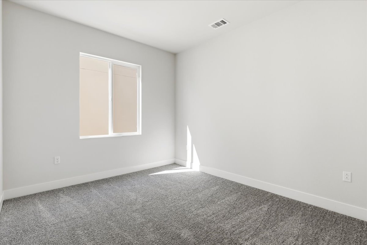 A room with a carpet and a window.