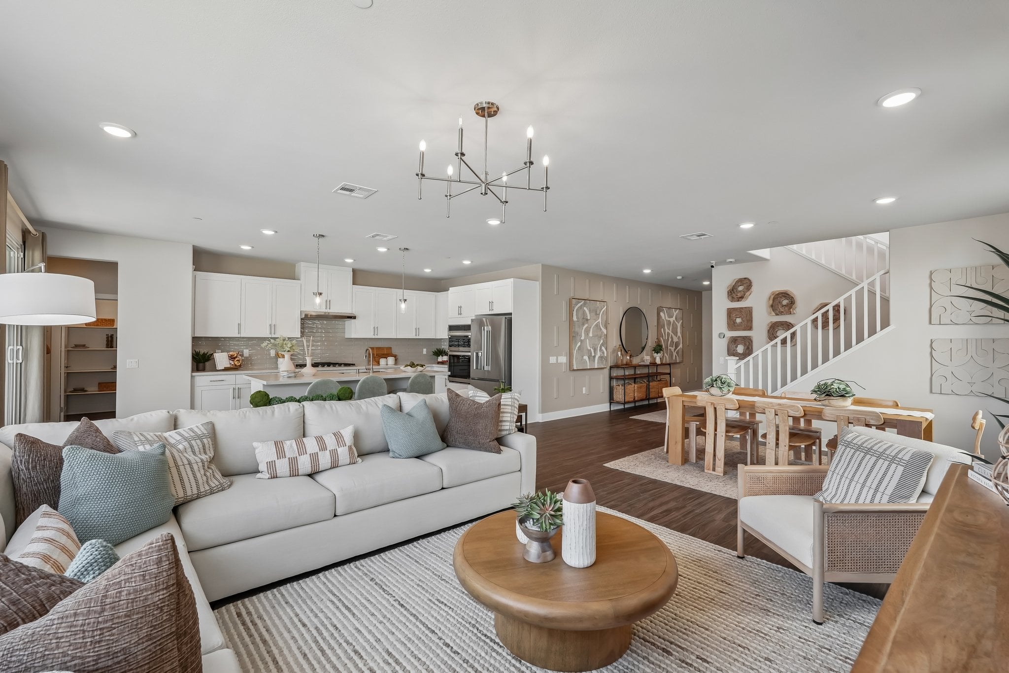 A large living room with a large chandelier and a large dining table.