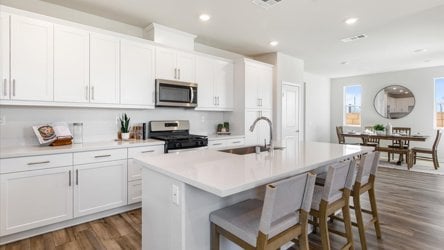 A kitchen with white cabinets.