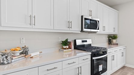 A kitchen with white cabinets.
