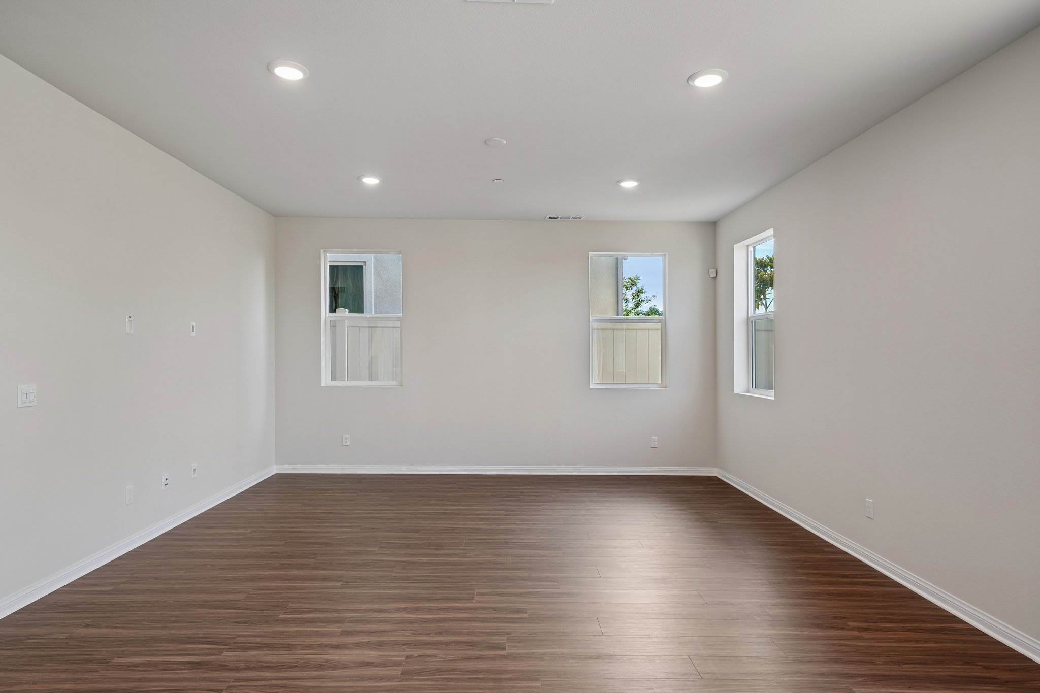 A room with a wood floor and white walls.
