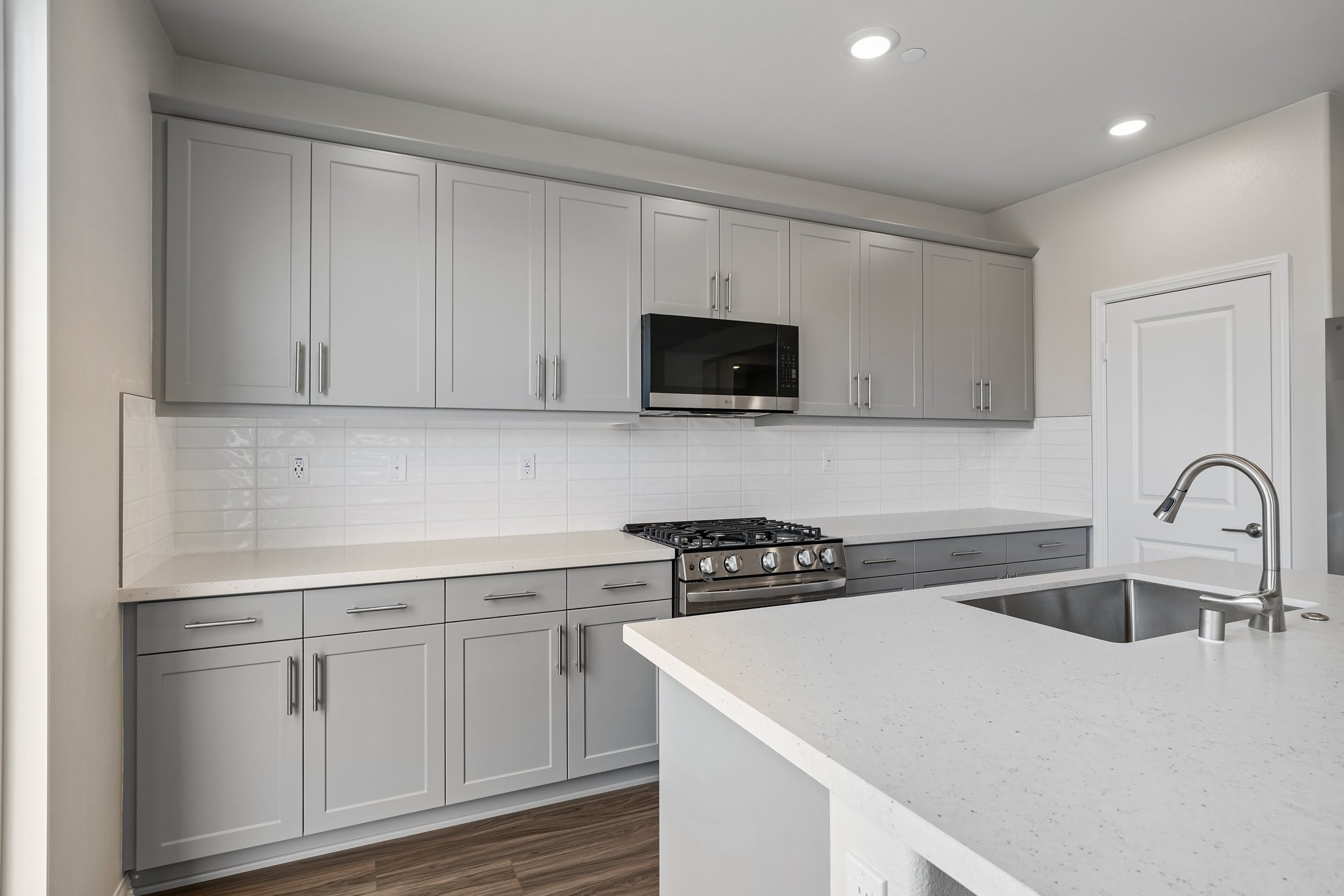 A kitchen with white cabinets.