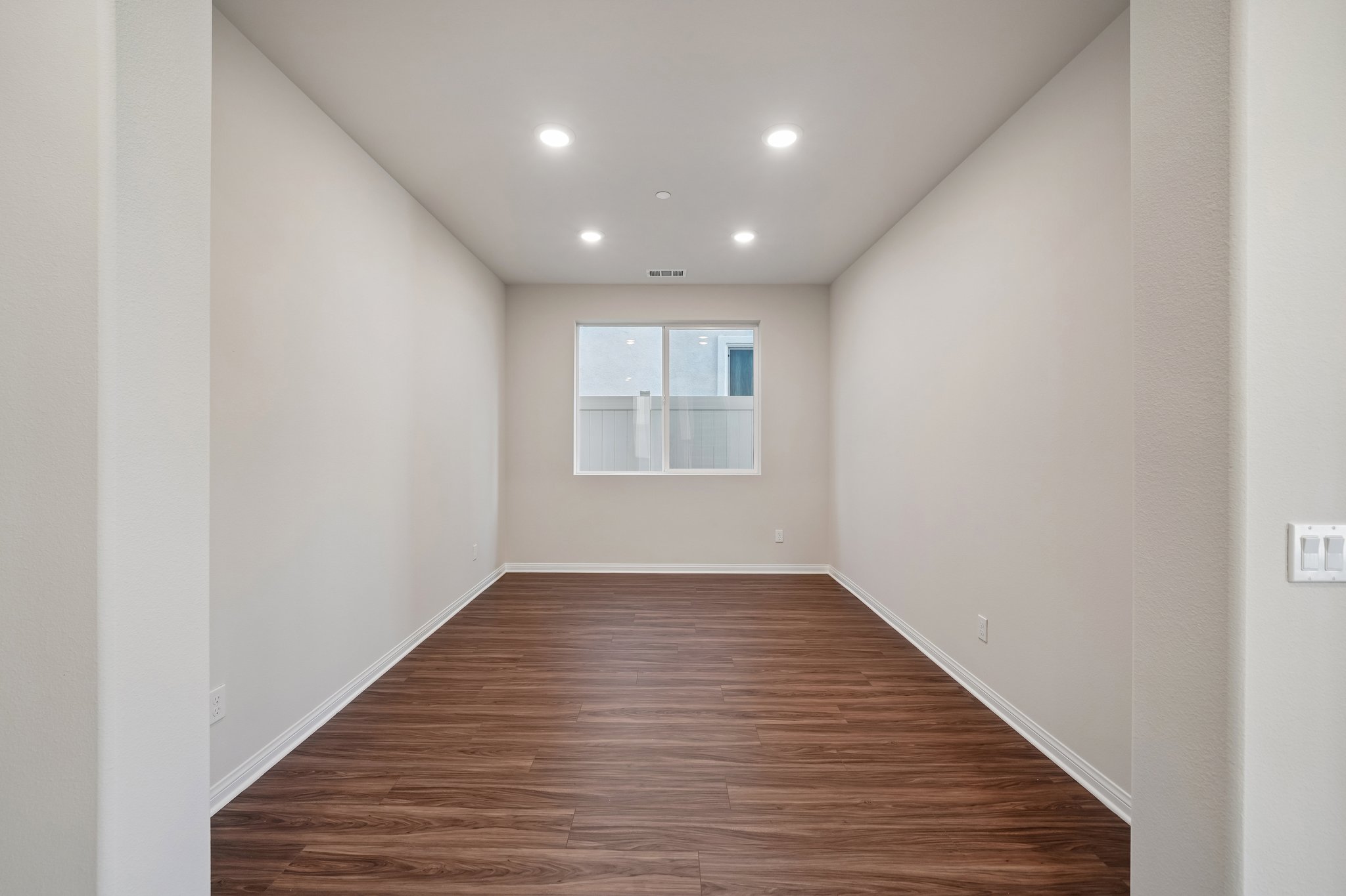 A room with a wood floor and a window.