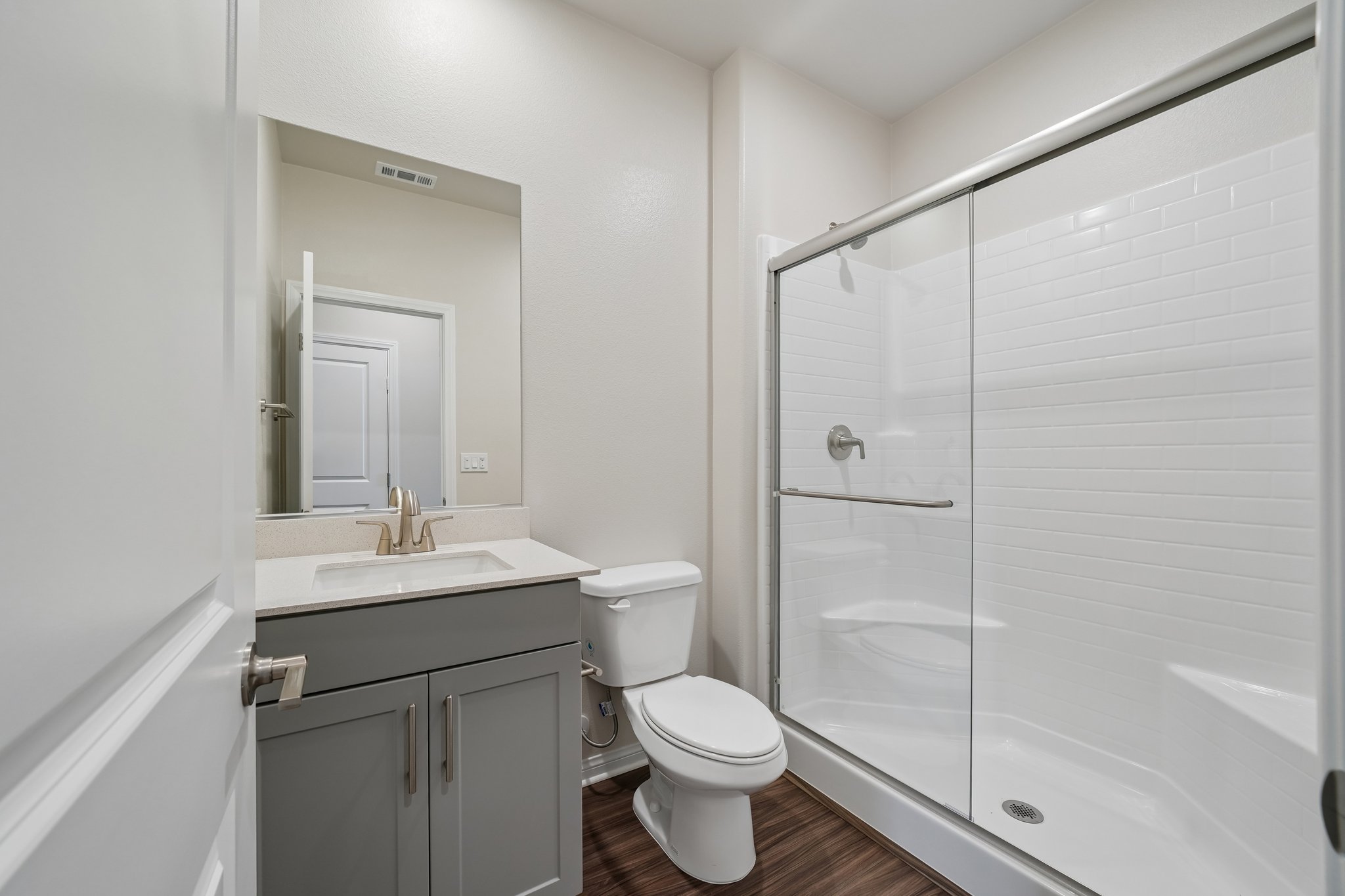 A bathroom with a shower and toilet.
