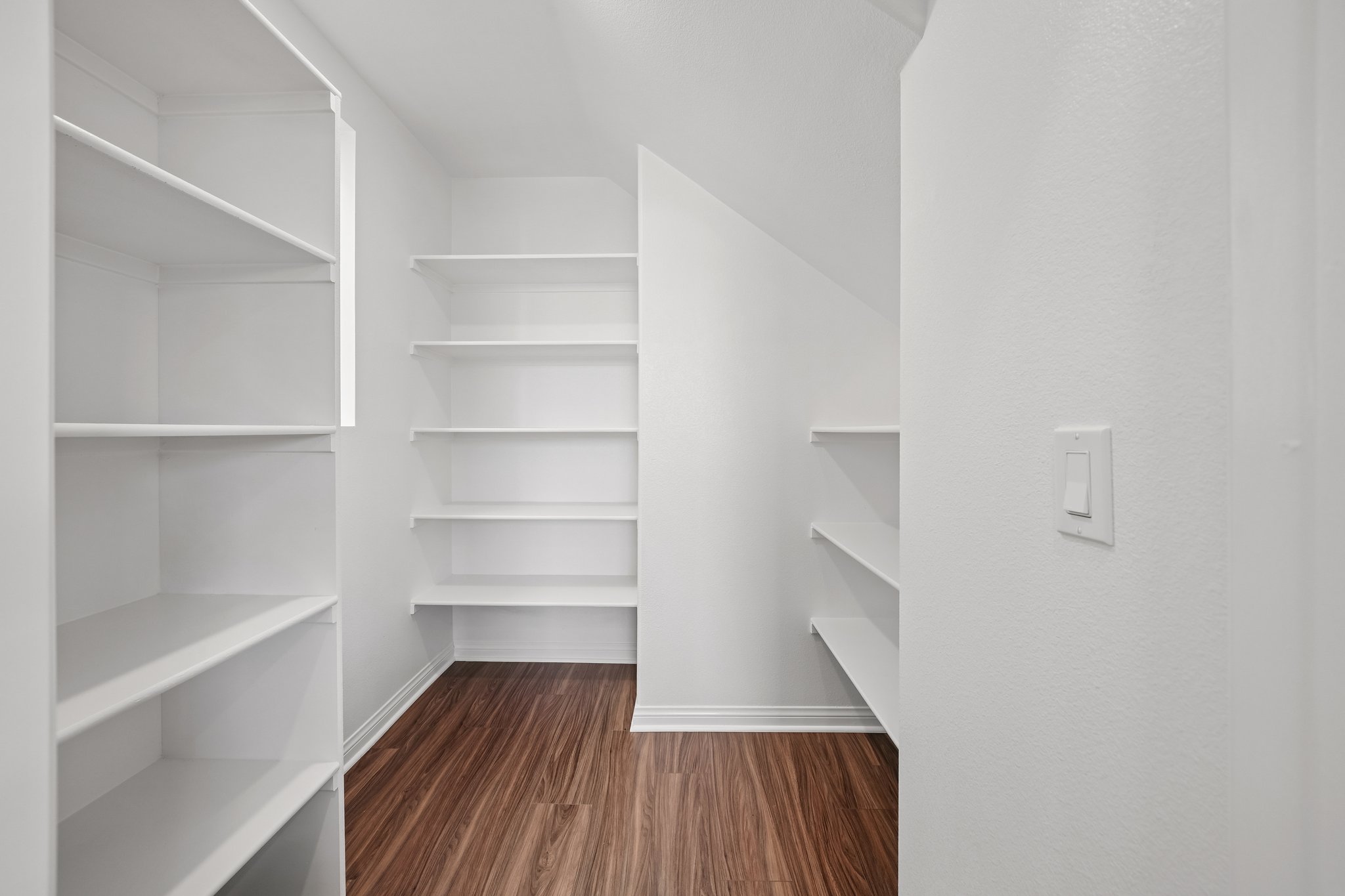 A white room with white shelves.
